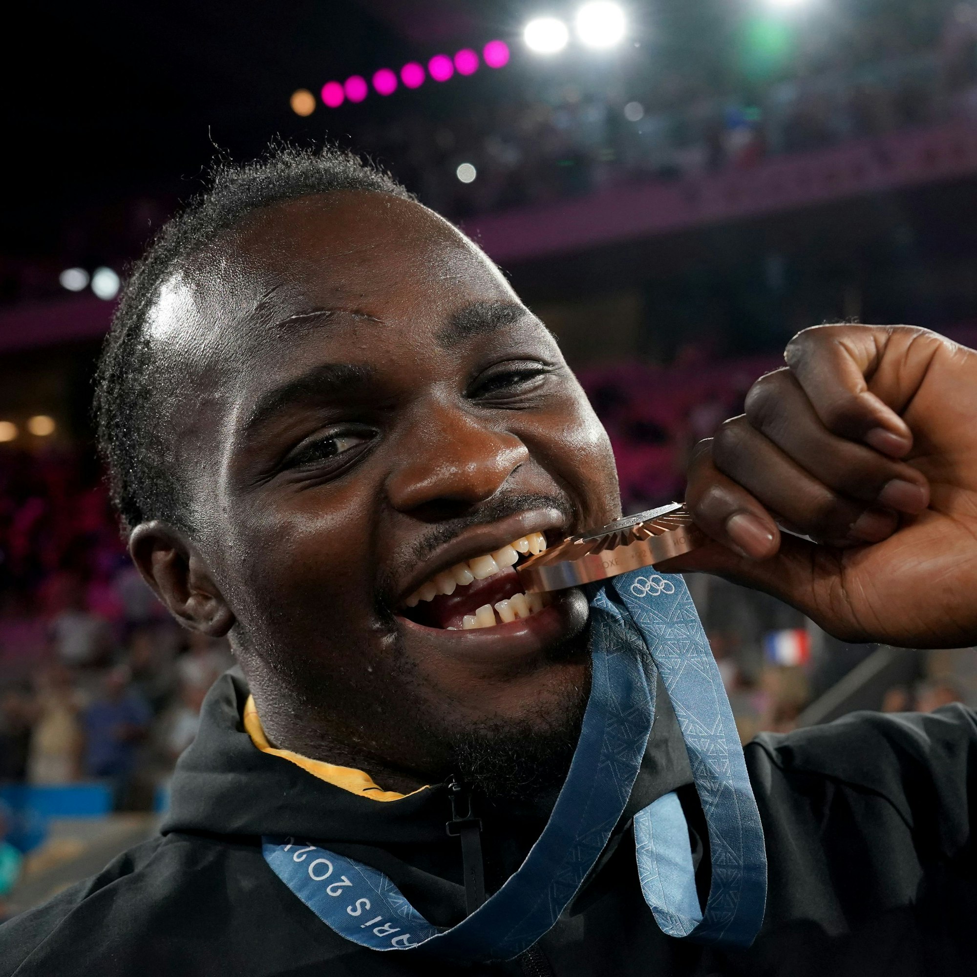 Ein Mann jubelt mit Medaille.