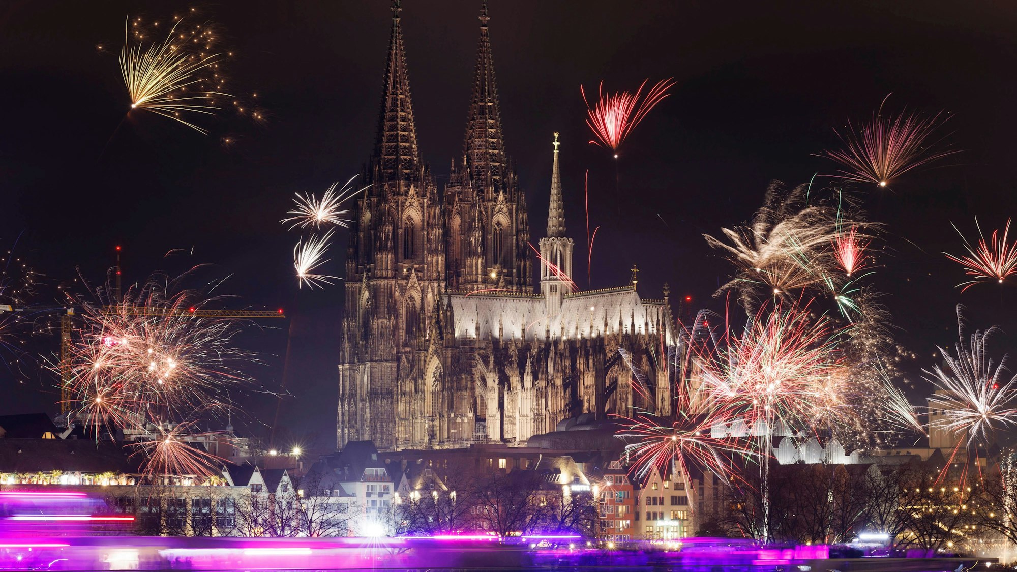 Viele Schaulustige haben sich auf dem Rheinboulevard eingefunden, um von Köln Deutz aus einen Blick auf den Kölner Dom und das Feuerwerk zu erhaschen.