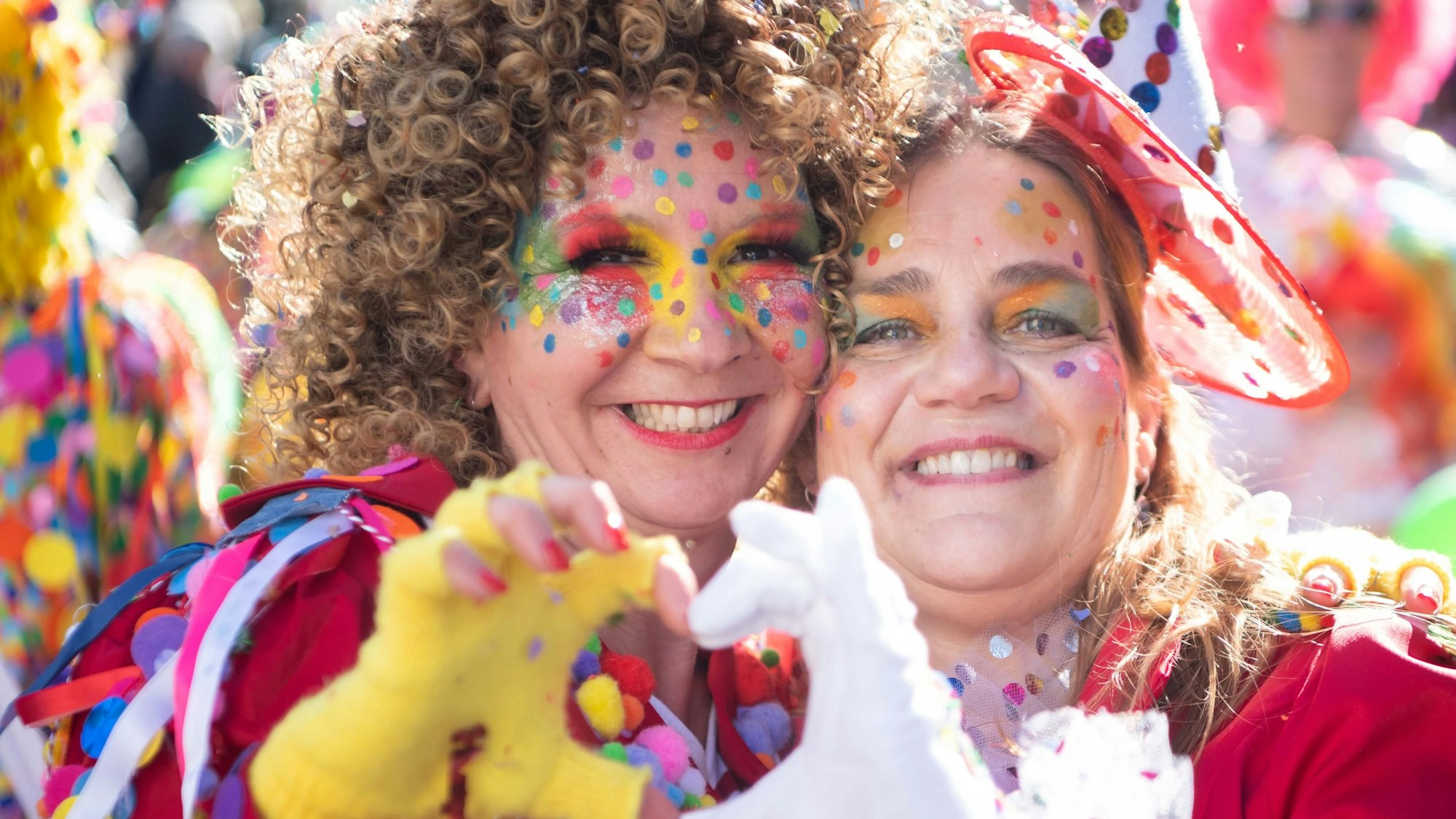 Zwei Zugteilnehmerinnen in Euskirchen formen auf diesem Archivfoto ihre Hände zu einem Herz.