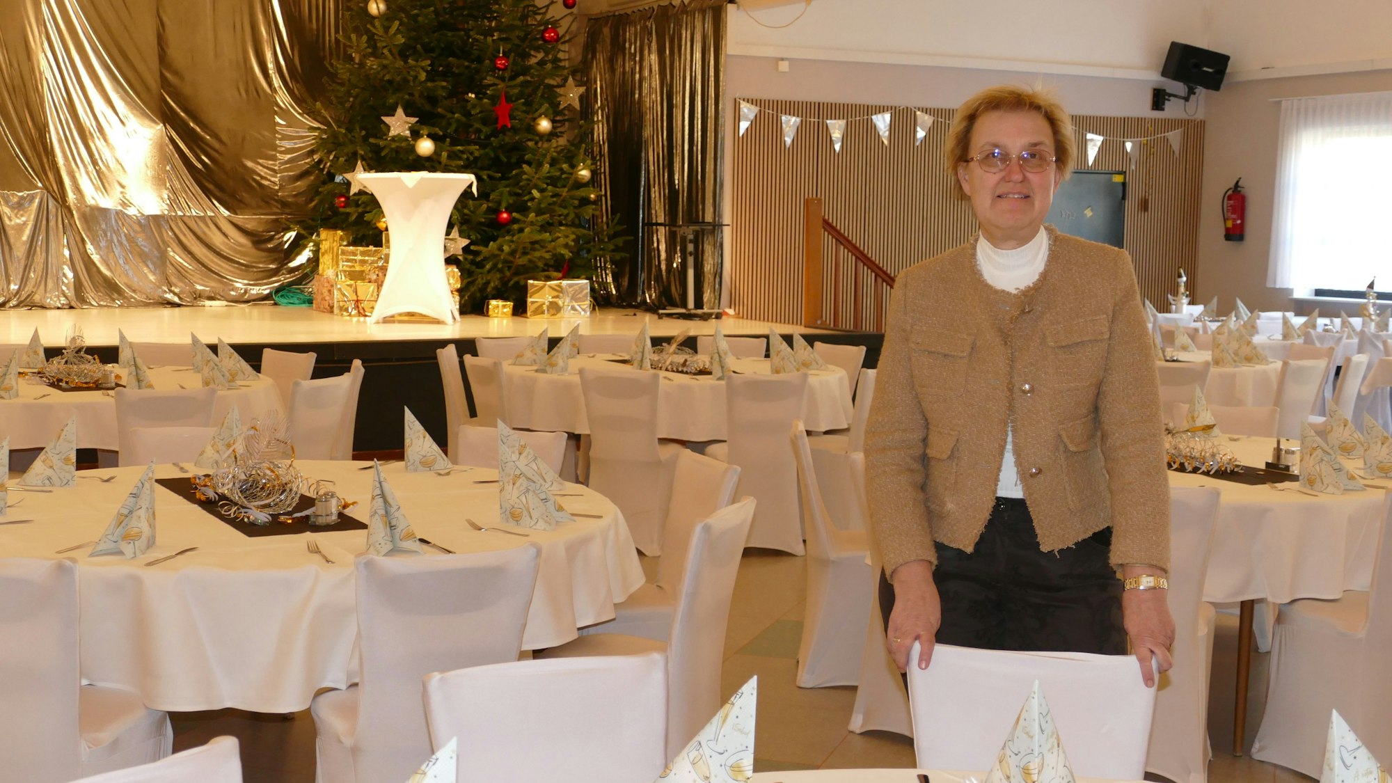 Eine Frau steht in einem Festsaal.