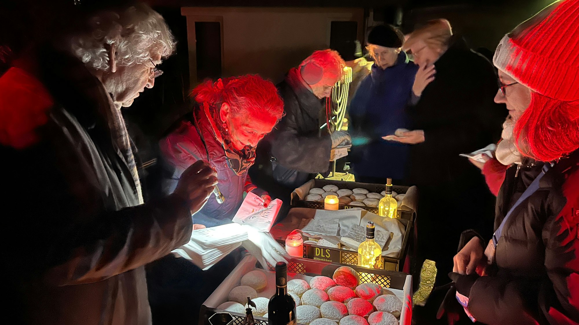 Zwei Frauen und ein Mann verteilen Berliner.