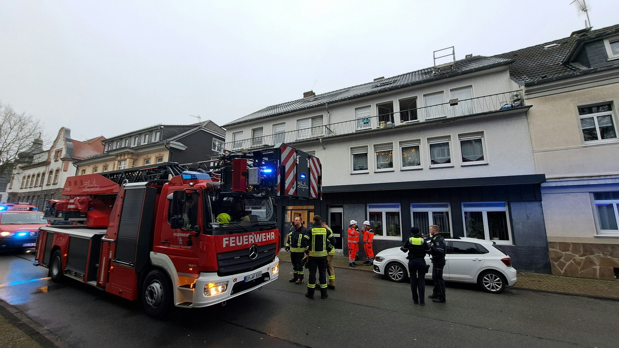 Das Foto zeigt eine Wohnung in der Bahnstraße, ein Feuerwehrfahrzeug und mehrere Einsatzkräfte.