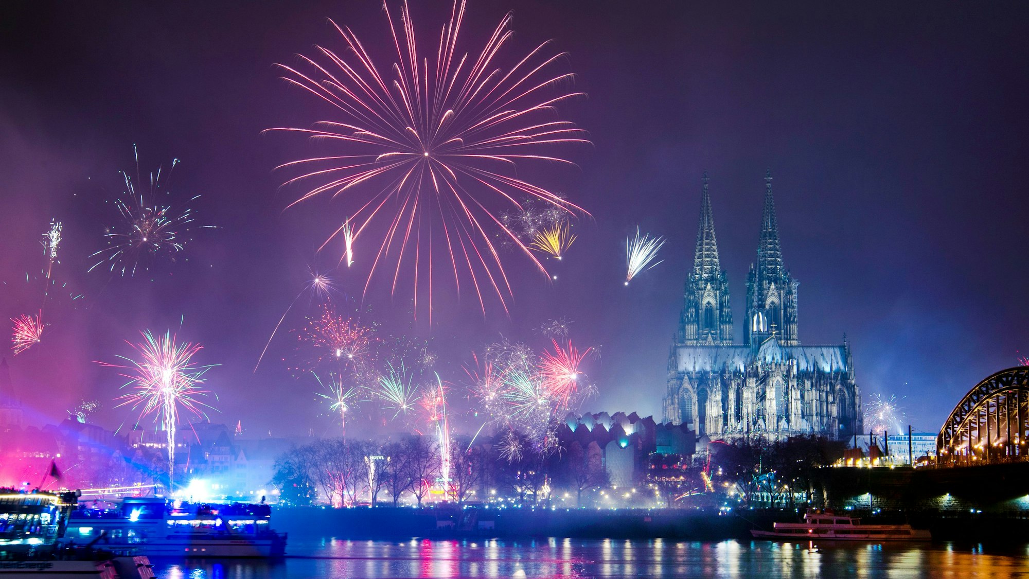 ARCHIV - 01.01.2019, Nordrhein-Westfalen, Köln: Feuerwerk ist in der Silvesternacht am Rhein über dem Dom zu sehen.