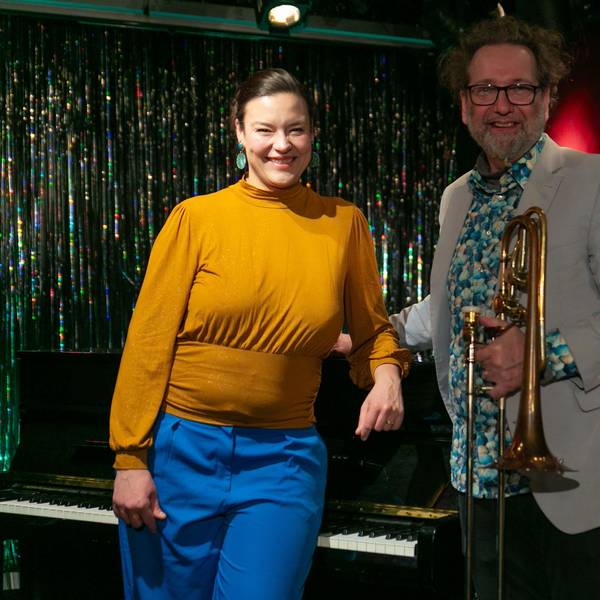 Eine Frau und ein Mann stehen am Klavier.