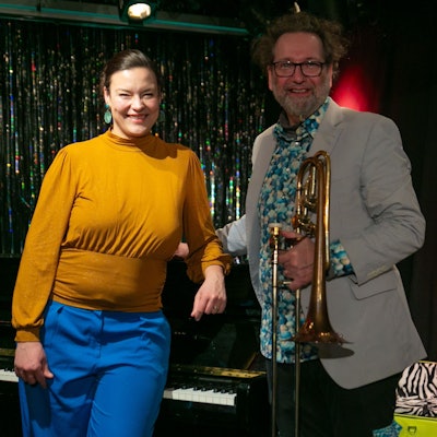 Eine Frau und ein Mann stehen am Klavier.