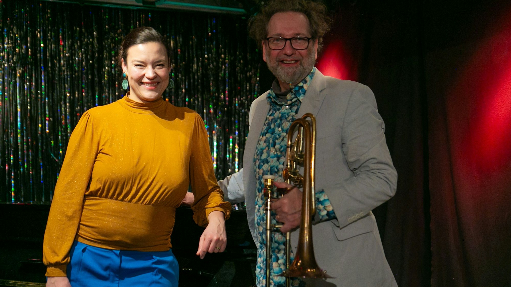 Eine Frau und ein Mann stehen am Klavier.