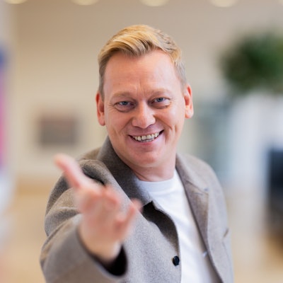 Das Foto zeigt den Influencer Jens „Knossi“ Knossalla mit ausgestreckter Hand.