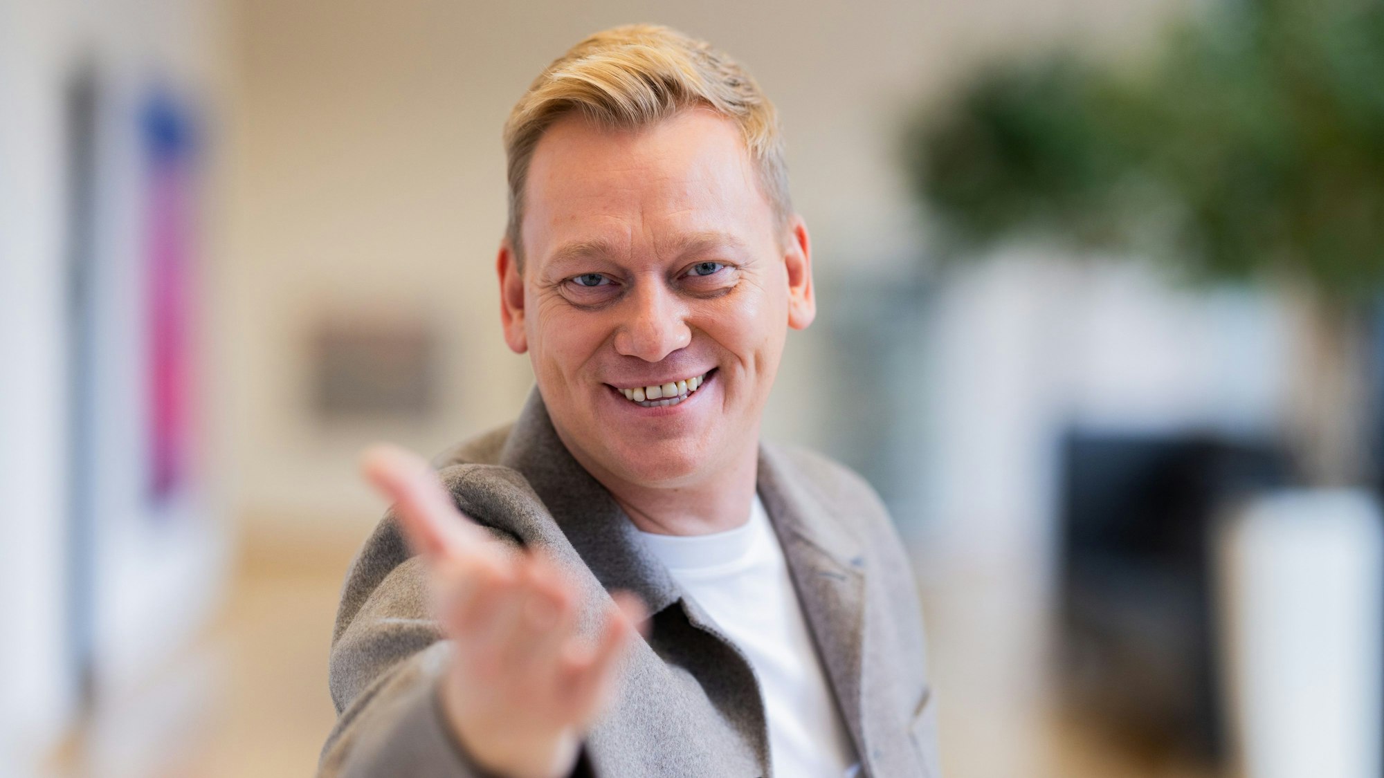 Das Foto zeigt den Influencer Jens „Knossi“ Knossalla mit ausgestreckter Hand.