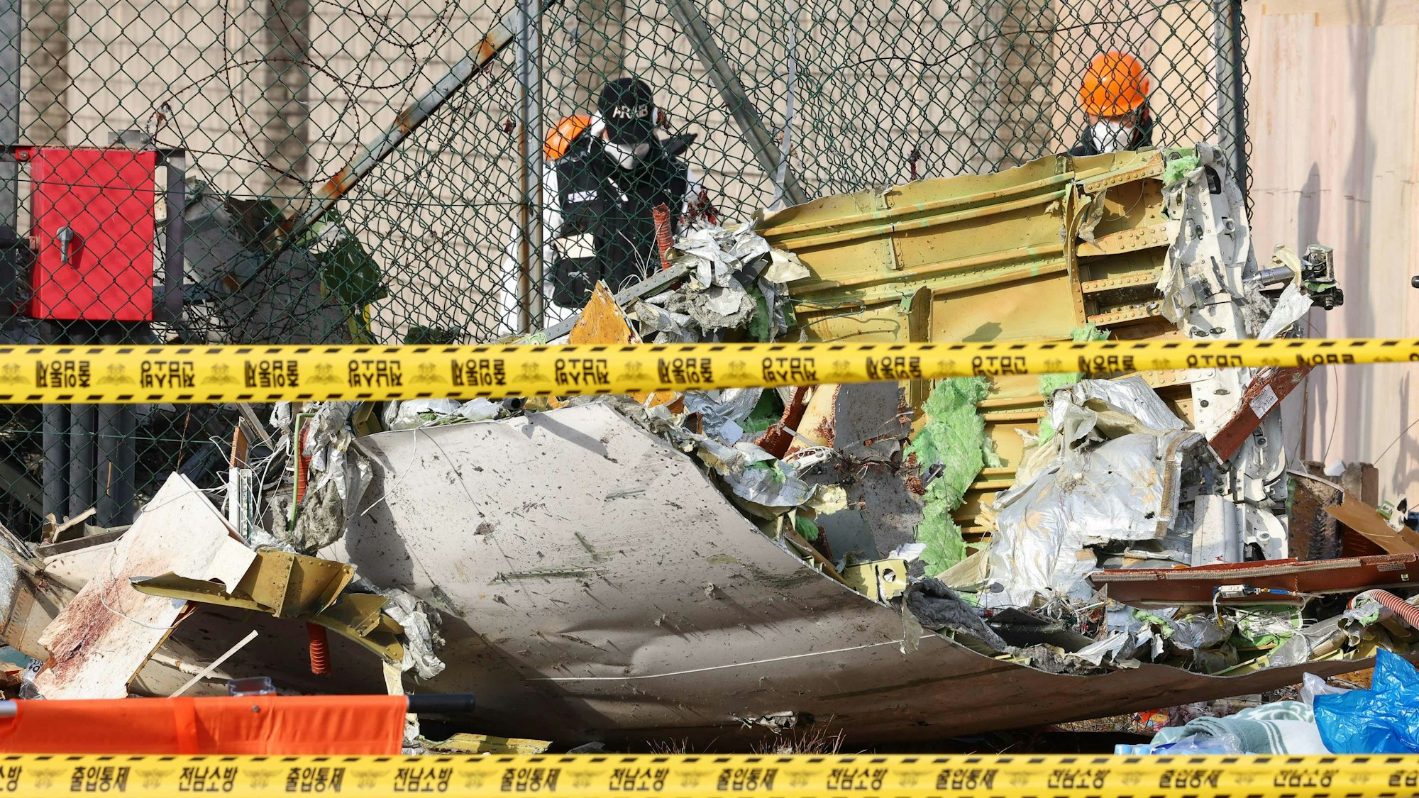 This picture shows wreckage at the scene where a Jeju Air Boeing 737-800 series aircraft crashed and burst into flames at Muan International Airport in Muan, some 288 kilometres southwest of Seoul on December 30, 2024. The Boeing 737-800 was carrying 181 people from Thailand to South Korea when it crashed on arrival on December 29, killing everyone aboard -- save two flight attendants pulled from the twisted wreckage of the worst aviation disaster on South Korean soil. (Photo by YONHAP / AFP) / - South Korea OUT / RESTRICTED TO SUBSCRIPTION USE - NO ARCHIVES