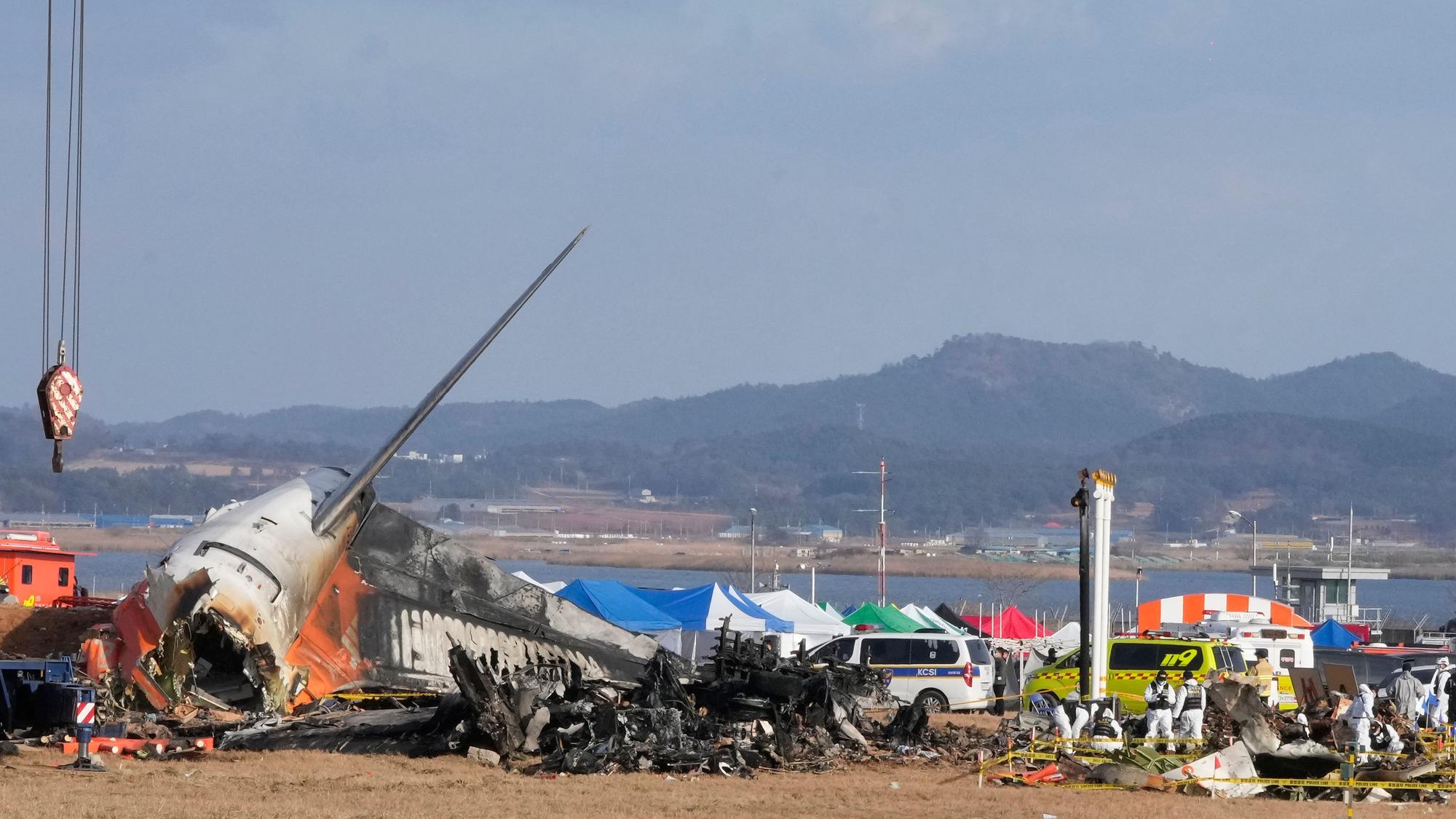 Mitglieder eines Rettungsteams arbeiten am verunglückten Passagierflugzeug am internationalen Flughafen Muan.