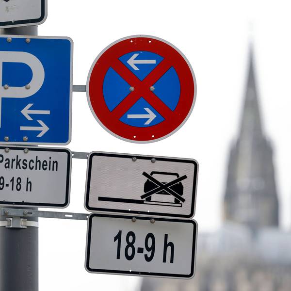 Im Bild ein Parkverbotsschild mit Parkplatzschild am Deutzer Rheinufer, im Hintergrund der Kölner Dom.