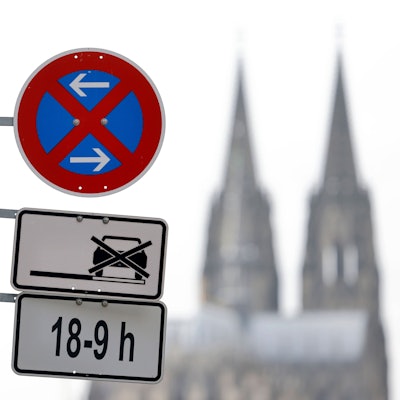 Im Bild ein Parkverbotsschild mit Parkplatzschild am Deutzer Rheinufer, im Hintergrund der Kölner Dom.