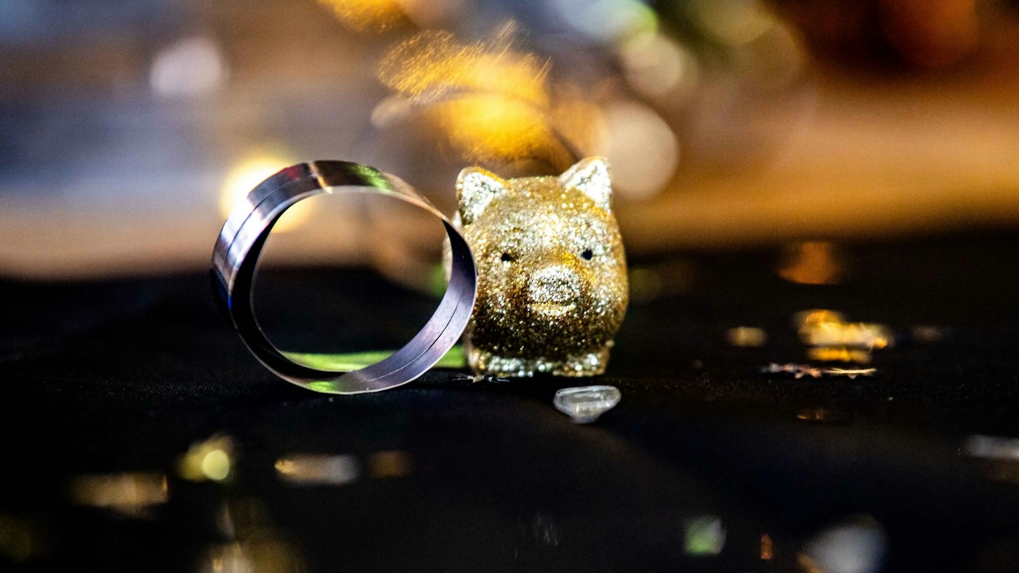 Die Detailaufnahme zeigt ein goldenes Miniatur-Glücksschweinchen.