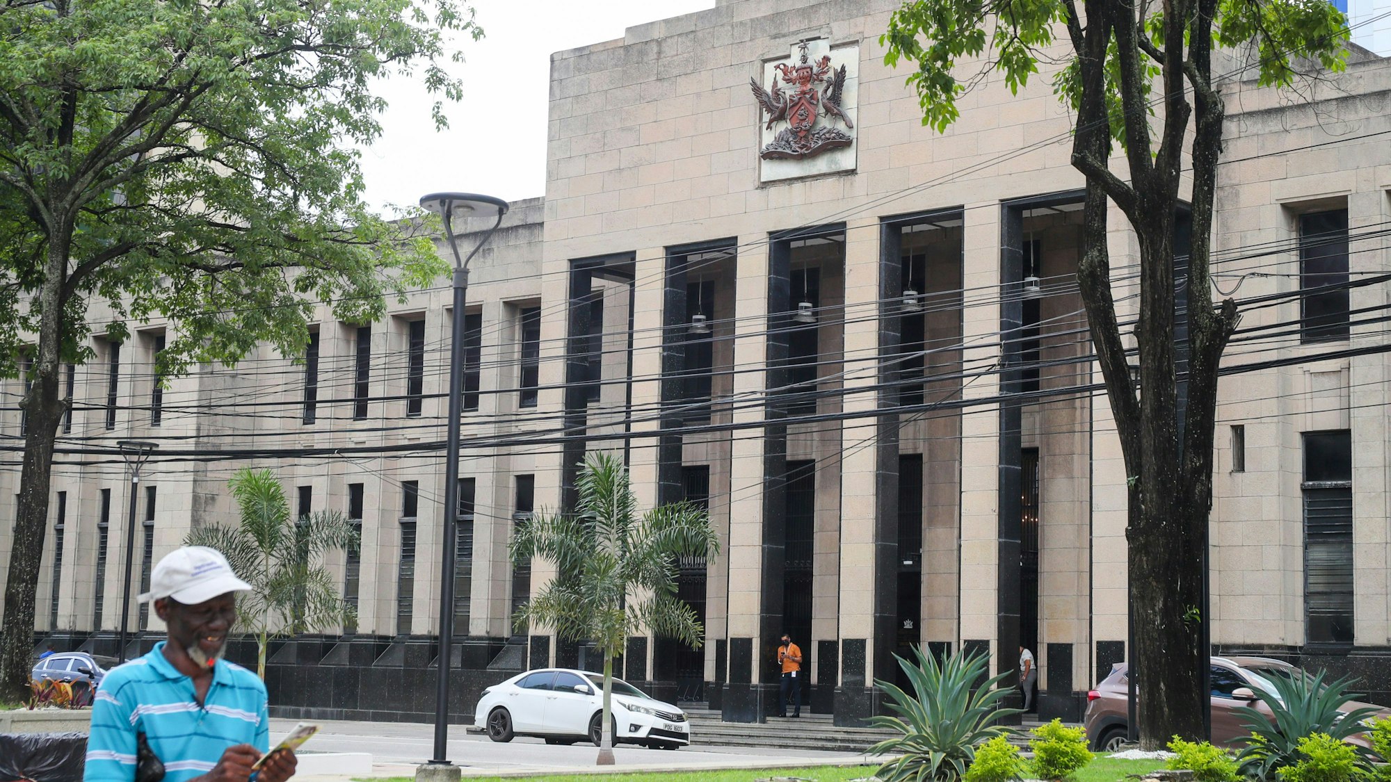 Das Wappen von Trinidad und Tobago hängt an der Fassade eines Regierungsgebäudes.