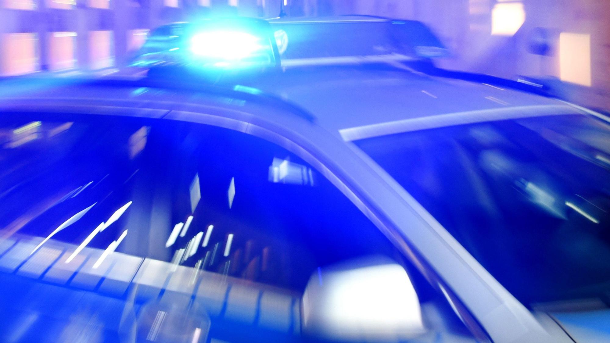 ARCHIV - 06.08.2015, Schleswig-Holstein, Flensburg: ILLUSTRATION - Ein Streifenwagen der Polizei steht mit eingeschaltetem Blaulicht auf der Straße. (zu dpa: «Mann soll zwei Frauen und ein Kind verletzt haben») Foto: Carsten Rehder/dpa +++ dpa-Bildfunk +++