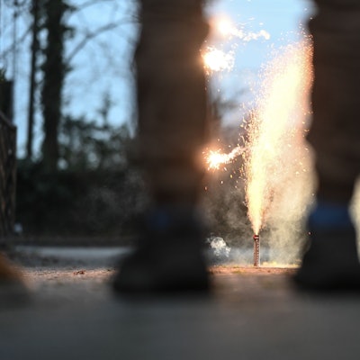 Eine Gruppe junger Menschen steht vor einer Feuerweks-Fontäne. (Symbolbild)