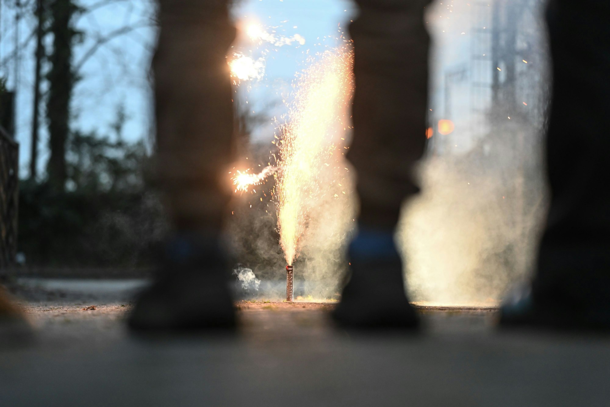 Eine Gruppe junger Menschen steht vor einer Feuerweks-Fontäne. (Symbolbild)