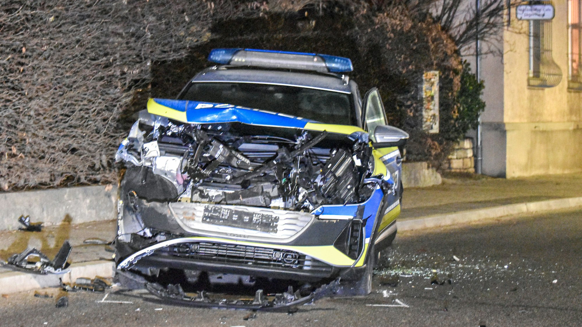 Ein demoliertes Polizeiauto steht nach der Verfolgungsfahrt auf einer Straße.