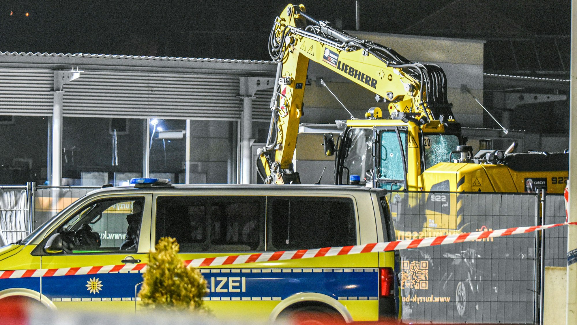 Ein Bagger steht nach einer mutmaßlichen Amokfahrt neben einem Autohaus in Tauberbischofsheim.