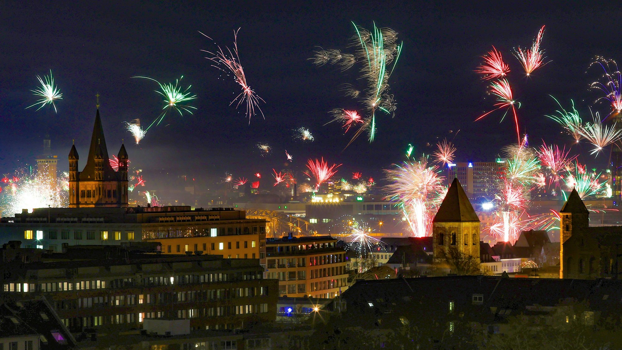Feuerwerk mit Blick auf das historische Rathaus und Groß St. Martin - fotografiert auf dem Dach des Hotels Wasserturm.