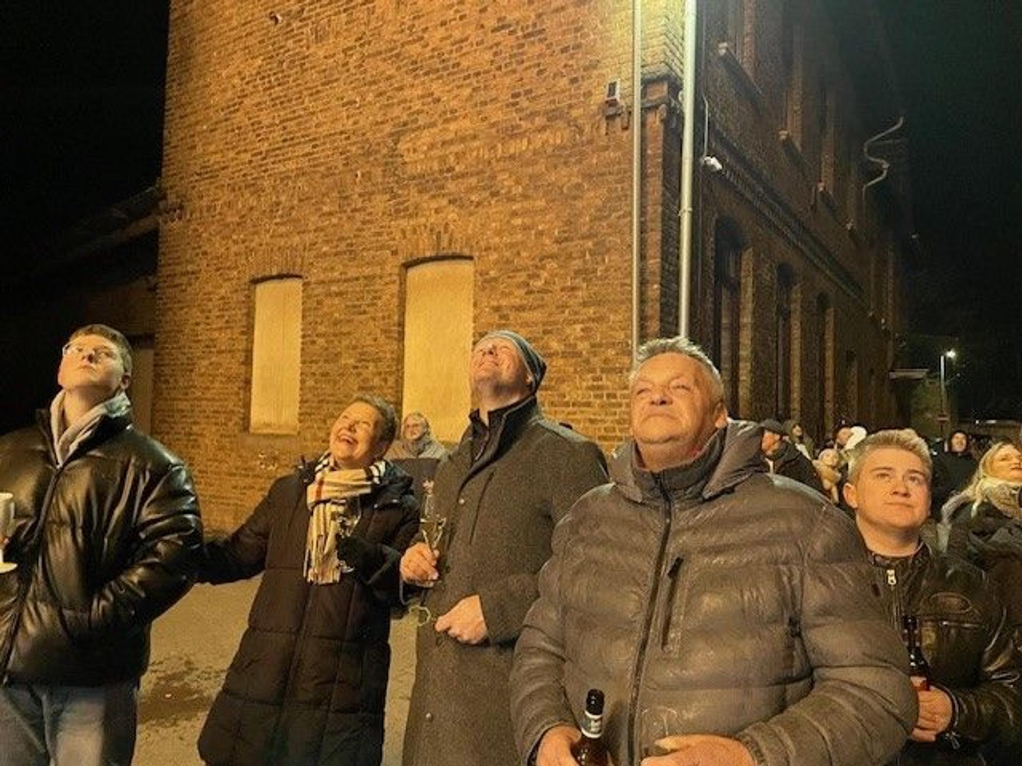 Das Bild zeigt mehrere Personen, die in den Himmel schauen.