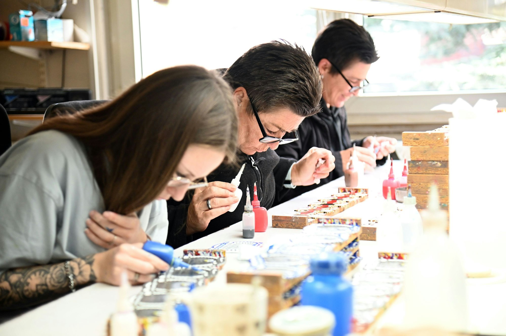 Frauen bemalen mit Farbtuben Orden.