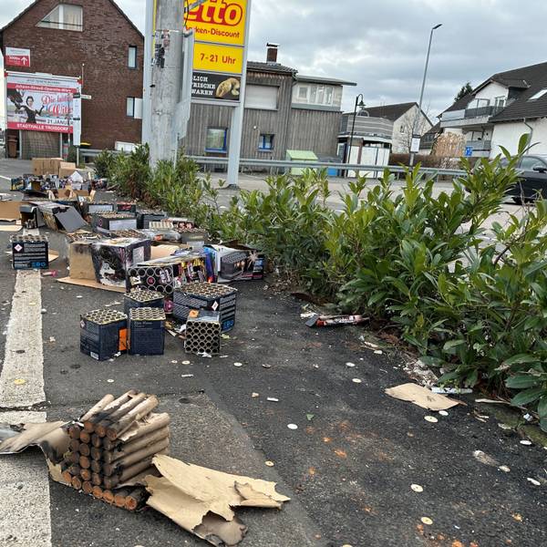 Vor einem Supermarkt an der Hauptstraße in Spich stapeln sich am Neujahrsmorgen Berge aus Feuerwerksresten.