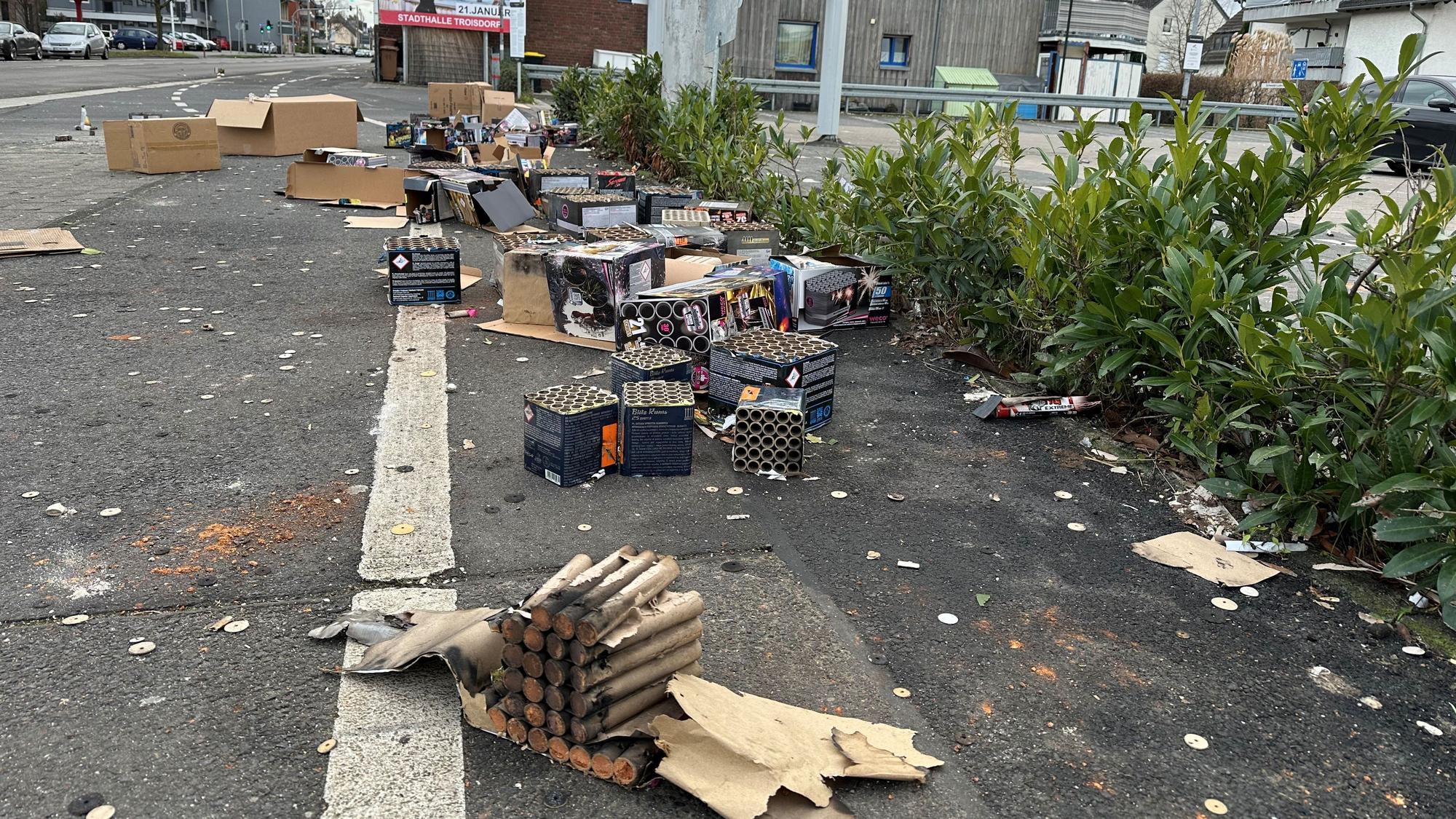 Vor einem Supermarkt an der Hauptstraße in Spich stapeln sich am Neujahrsmorgen Berge aus Feuerwerksresten.