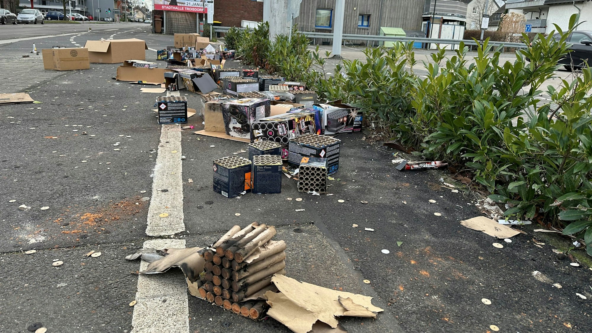 Vor einem Supermarkt an der Hauptstraße in Spich stapeln sich am Neujahrsmorgen Berge aus Feuerwerksresten.