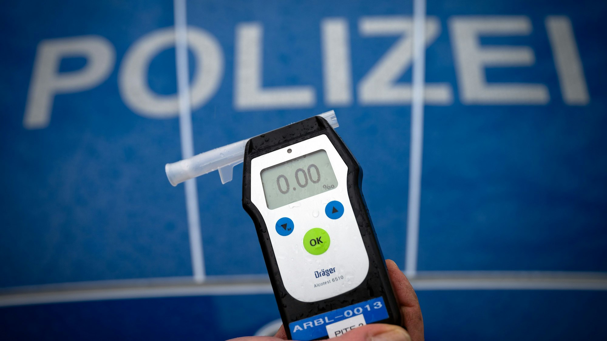 Ein Polizeibeamter hält während einer Verkehrskontrolle an der Berliner Straße ein Messgerät Alcotest, das den Alkoholwert von Null Promille anzeigt.
