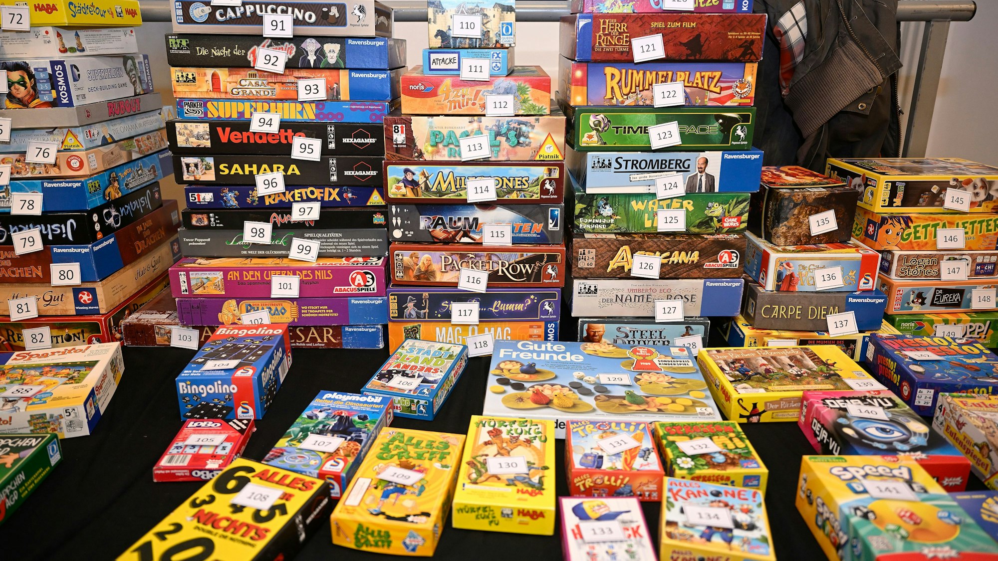 Gesellschaftsspiele stapeln sich auf einem Tisch.