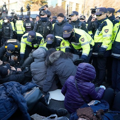 Polizeibeamte tragen Anhänger des angeklagten südkoreanischen Präsidenten Yoon Suk Yeol in der Nähe der Präsidentenresidenz weg.