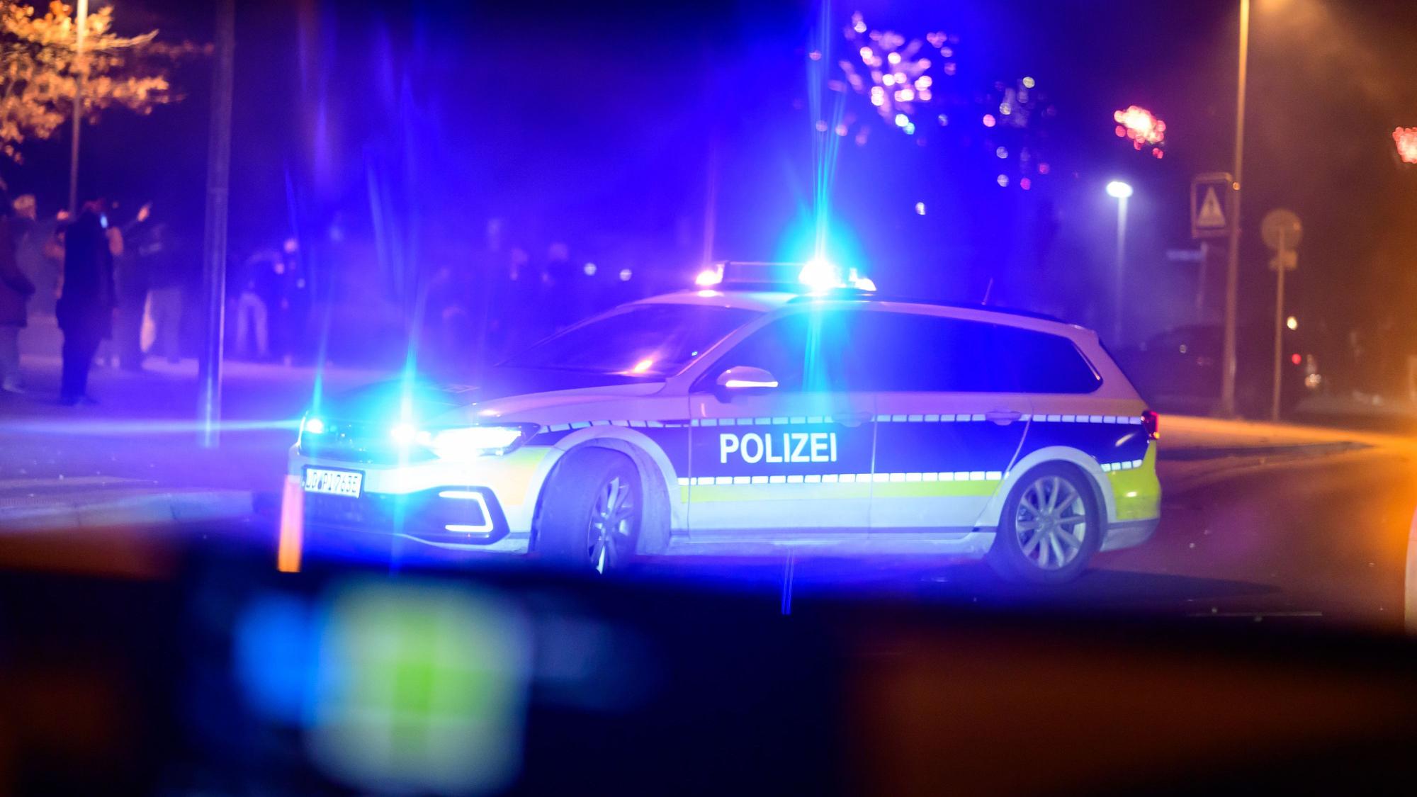 Ein Streifenwagen der Polizei versperrt den Weg auf einer Straße (Symbolfoto).