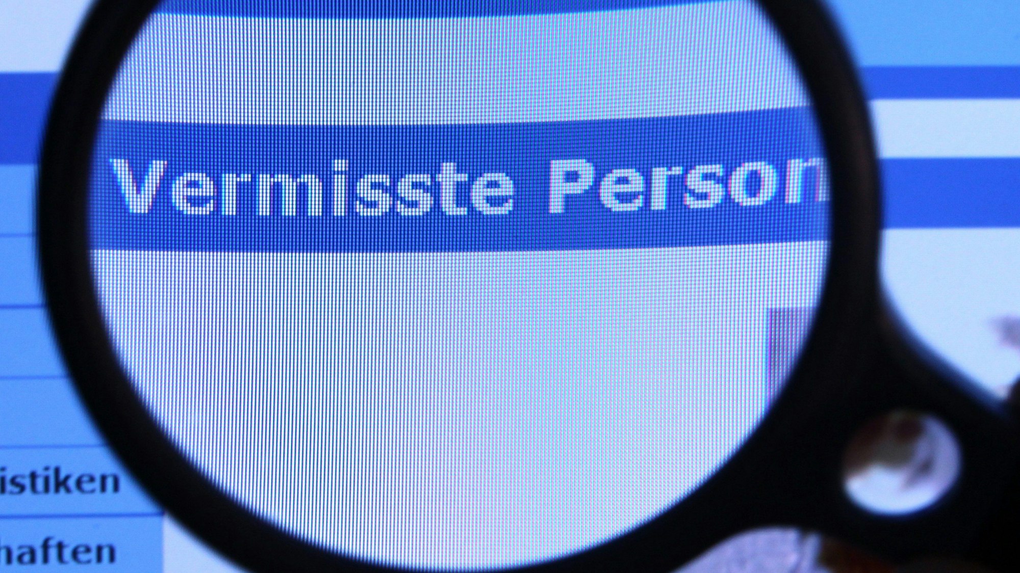 Hinter einer Lupe ist der Schriftzug «Vermisste Person» auf einem Fahndungsaufruf auf der Internetseite des Bundeskriminalamtes (BKA) zu sehen.