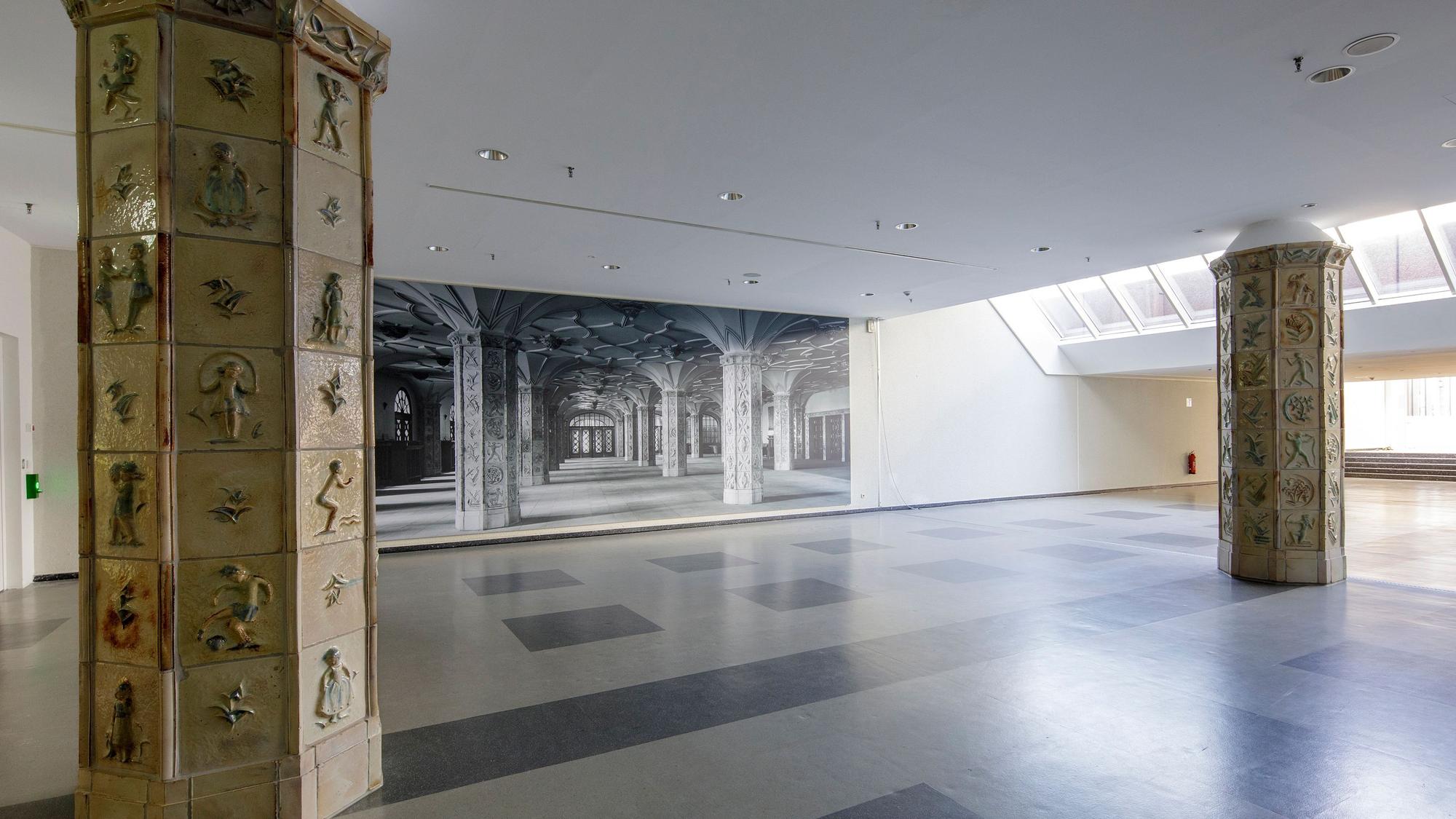 Auf dem Bild sind zwei rekonstruierte Säulen sowie eine vergrößerte SW-Ansicht der alten Wandelhalle zu sehen.