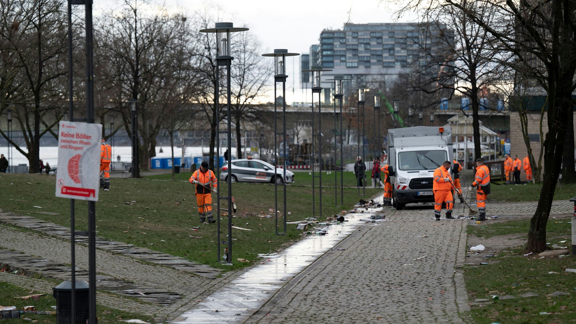 Im Rheingarten fegen Mitarbeitende der AWB die Wege und entsorgen den Müll.