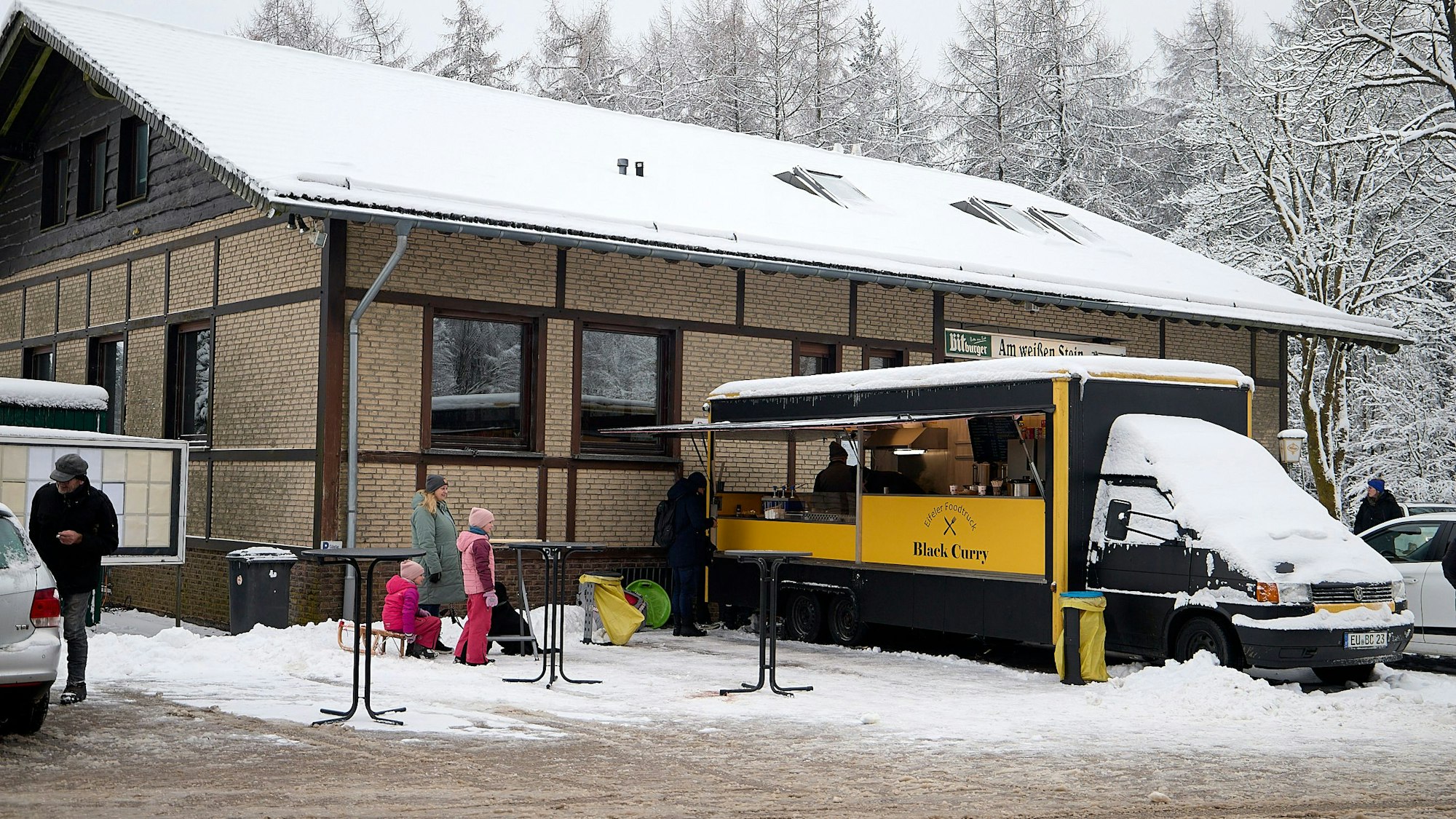 Der Imbisswagen steht vor dem Eingang des Restaurants bereit für hungrige Besucher.