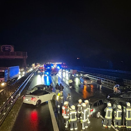 Das Bild zeigt mehrere Feuerwehrkräfte und verunfallte Autos auf der Autobahn.