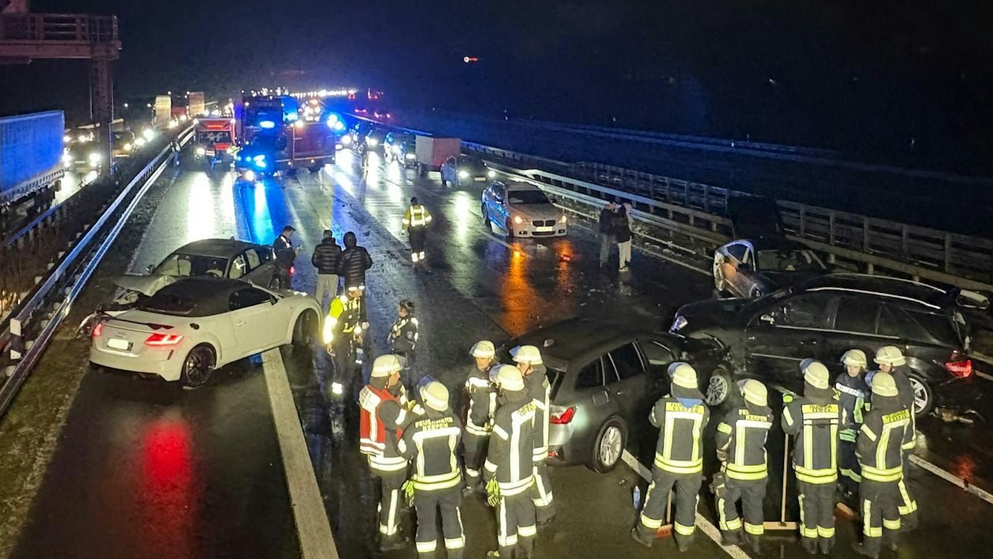 Das Bild zeigt mehrere Feuerwehrkräfte und verunfallte Autos auf der Autobahn.