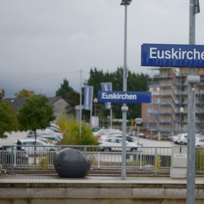 Auf zwei Schildern, die jeweils auf einem Bahnsteig platziert sind, steht der Ortsname Euskirchen.