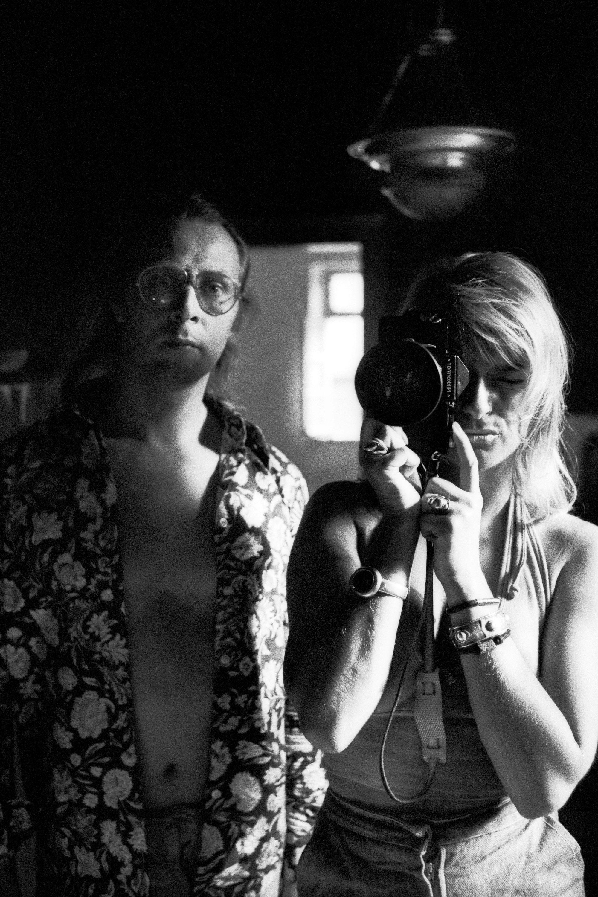 Angelika Platen und Sigmar Polke stehen vor einem Spiegel. Platen fotografiert.