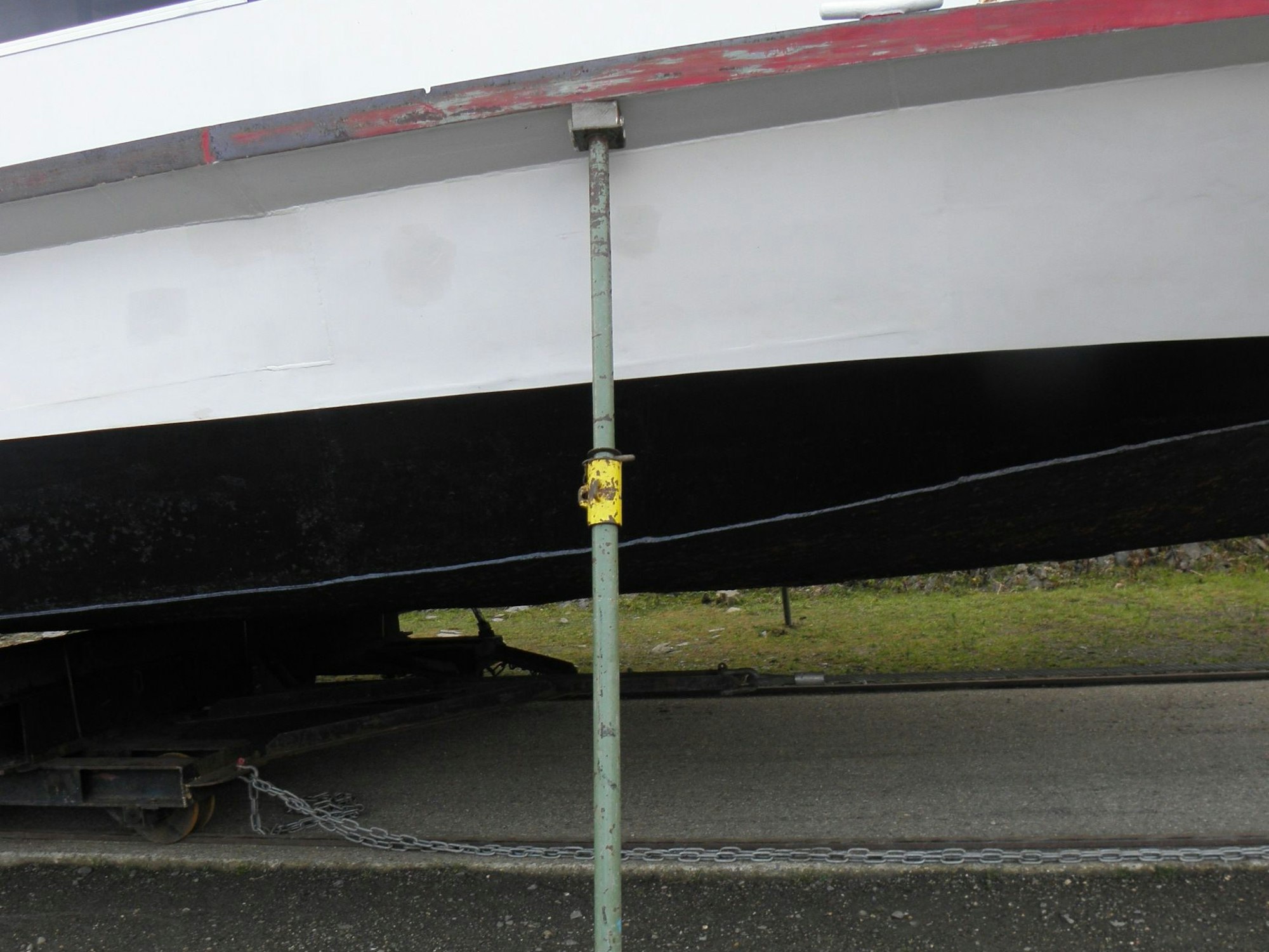 Das Bild zeigt eine von mehreren grünen Stahlstützen, die das Schiff Aachen, das derzeit an Land ist, gegen seitliches Umkippen sichern.