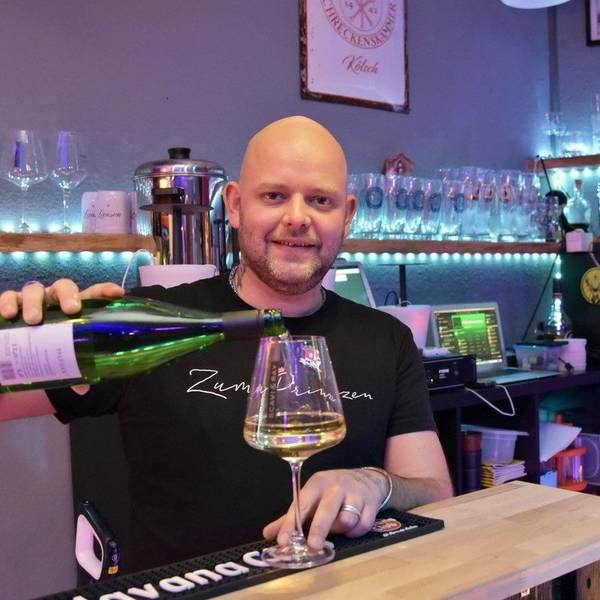 Ein kahlköpfiger Mann schenkt in der Siegburger Kneipe Zum Prinzen ein Glas Weißwein ein.