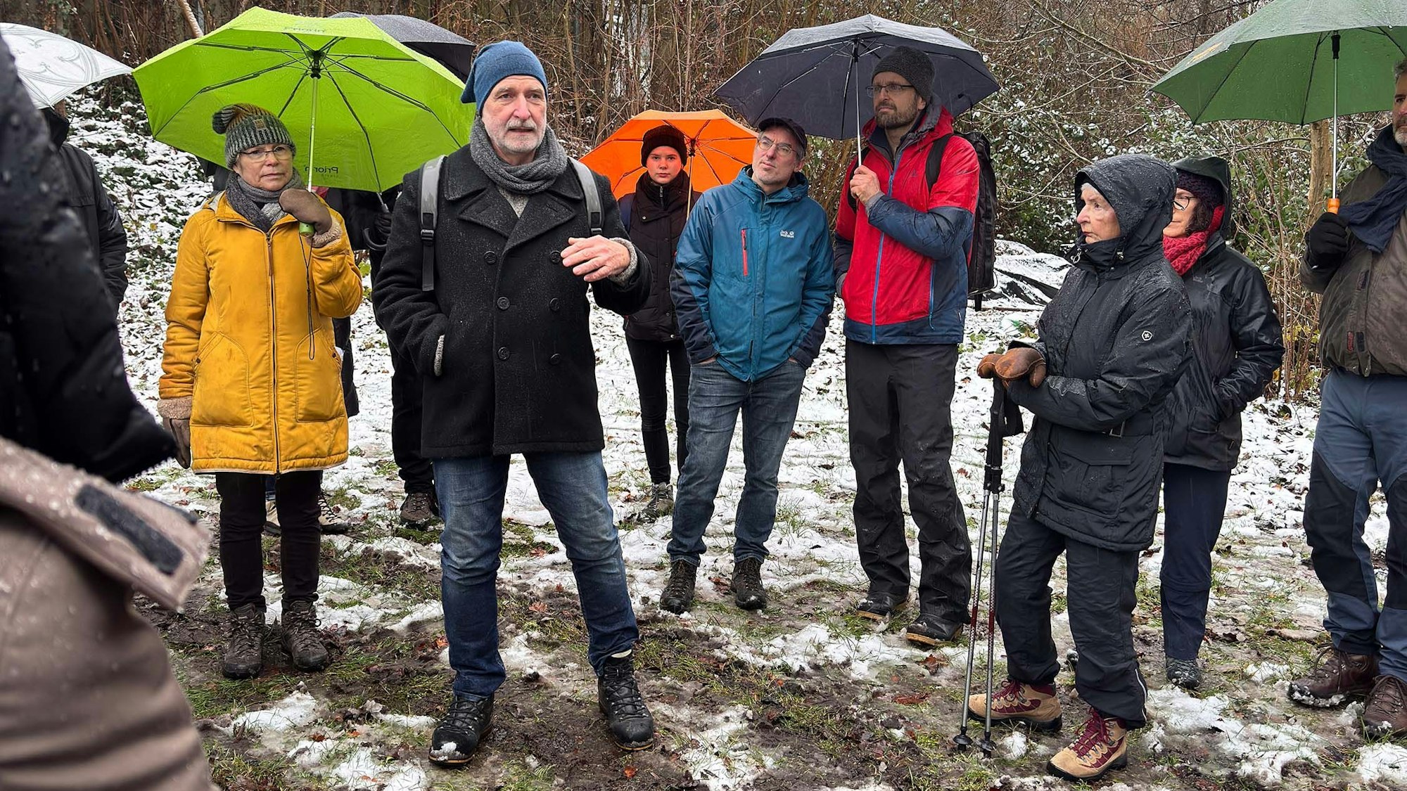 Eine Gruppe von Menschen steht um einen Mann herum.