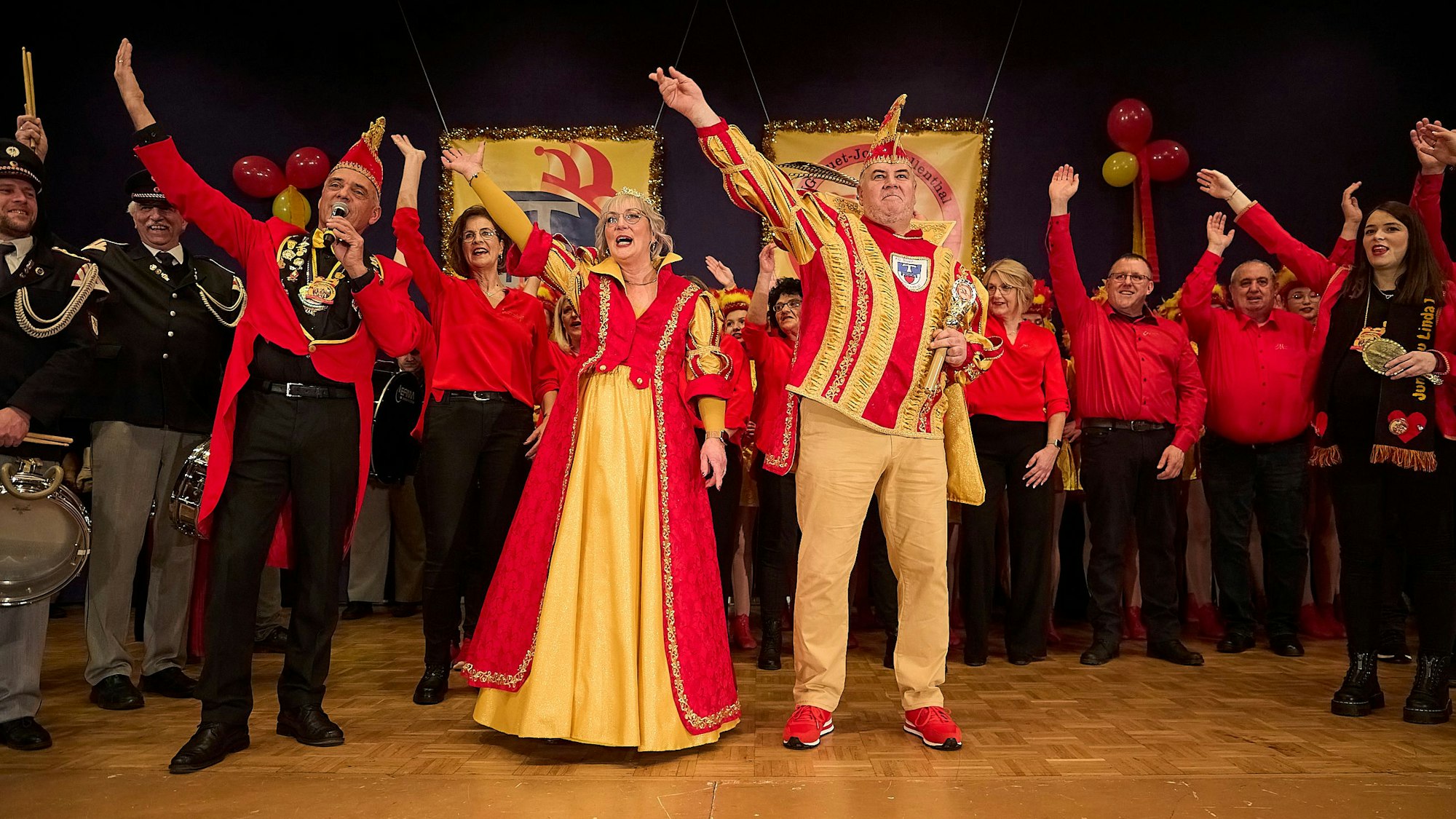 Das Prinzenpaar mit seinem Gefolge jubelt auf der Bühne den Jecken zu.