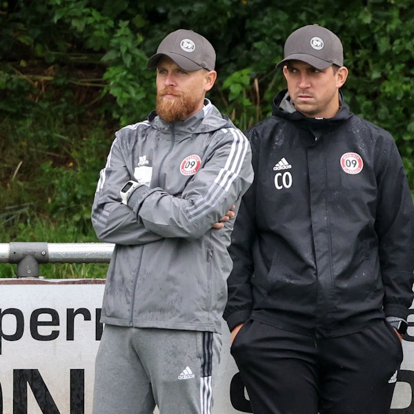 Mike Wunderlich und Andreas Dreiner stehen am Spielfeldrand.