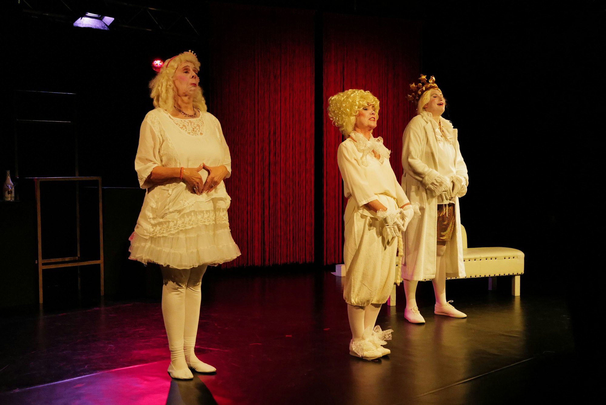 Drei Menschen in Kostümen stehen auf einer Bühne im Kaufhof in Siegburg.