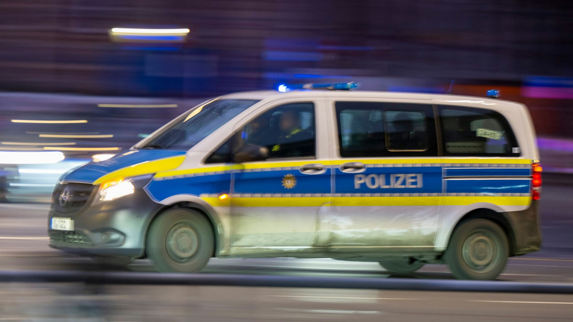 Ein Polizeiauto fährt mit Blaulicht zu einem Einsatz.