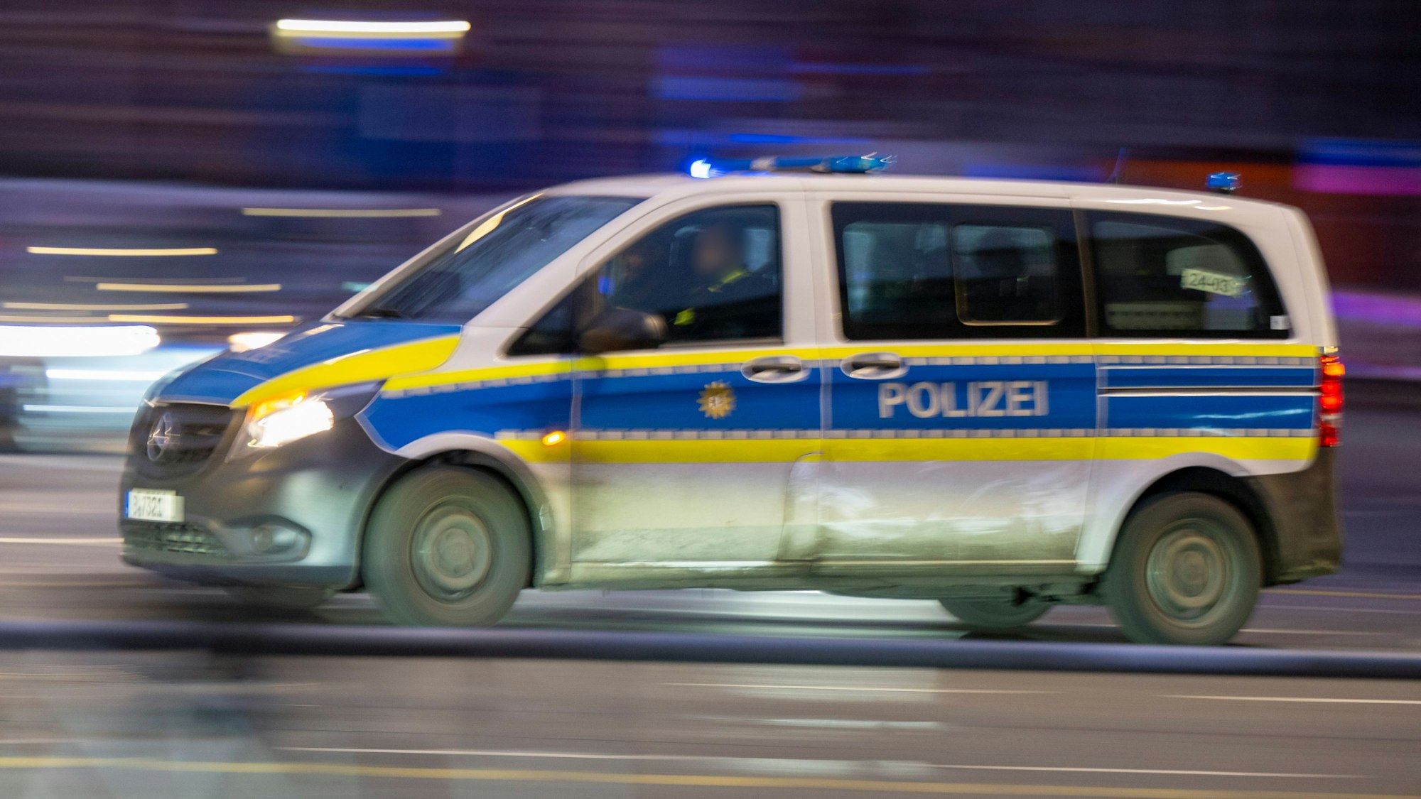 Ein Polizeiauto fährt mit Blaulicht zu einem Einsatz.