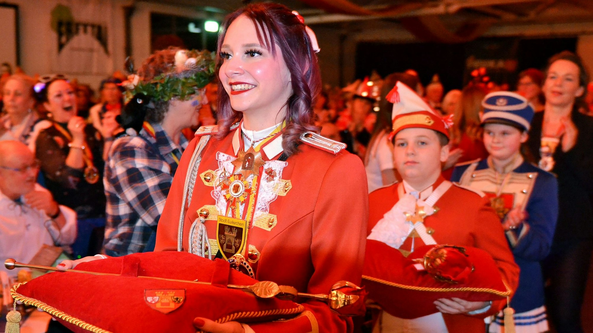 Tochter Vivian Pesch und der designierte Küfer Finn Wassong tragen auf Kissen die Insignien für das erste Euskirchener Prinzenpaar zur Bühne.